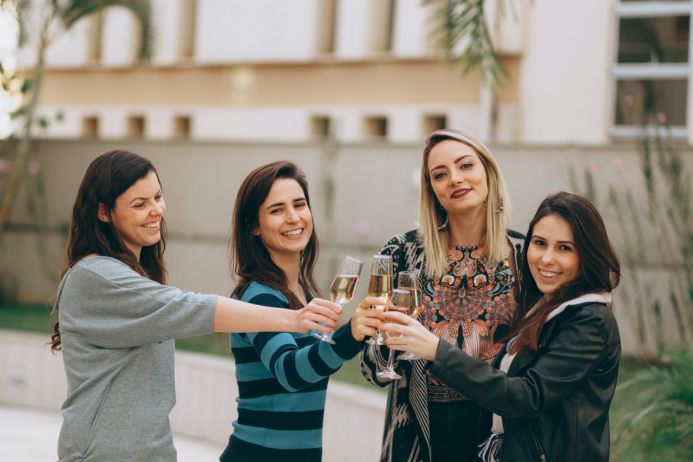 Women laughing and raising their glasses at an outdoor apéro