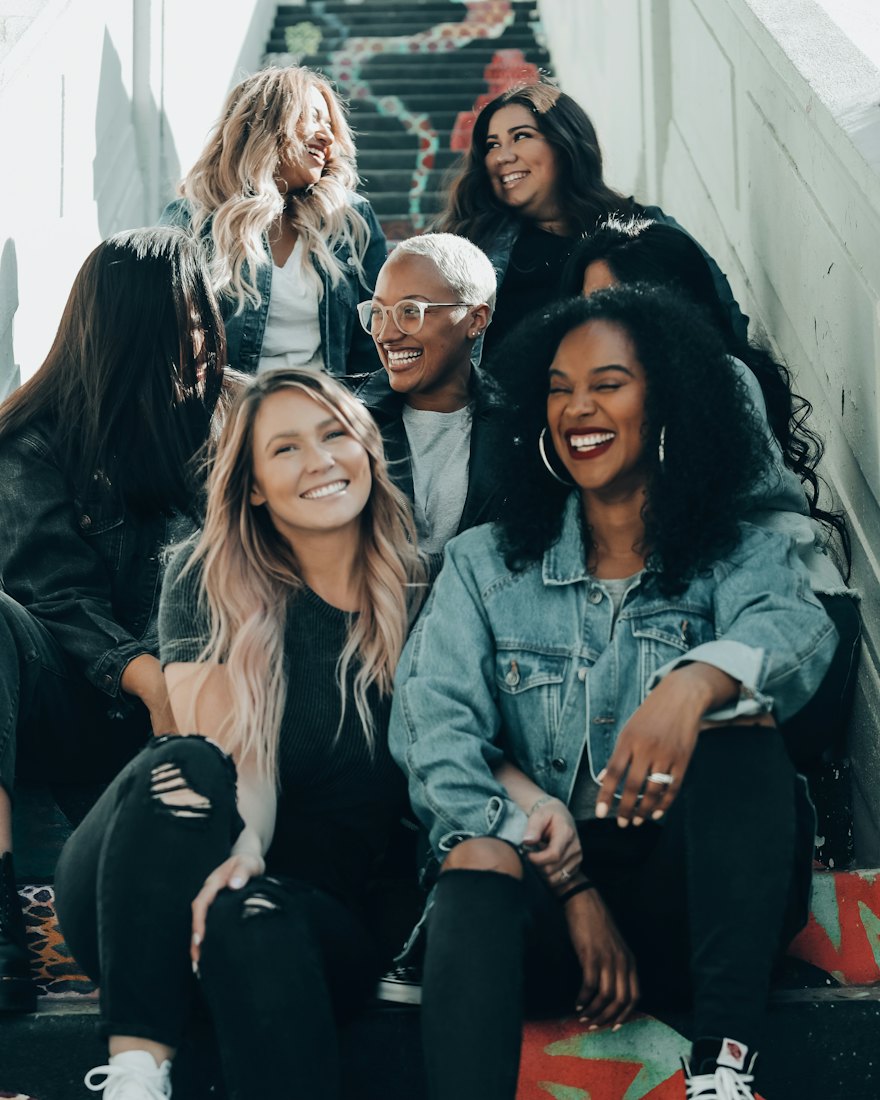 A group of friends laughing together on a flight of painted steps